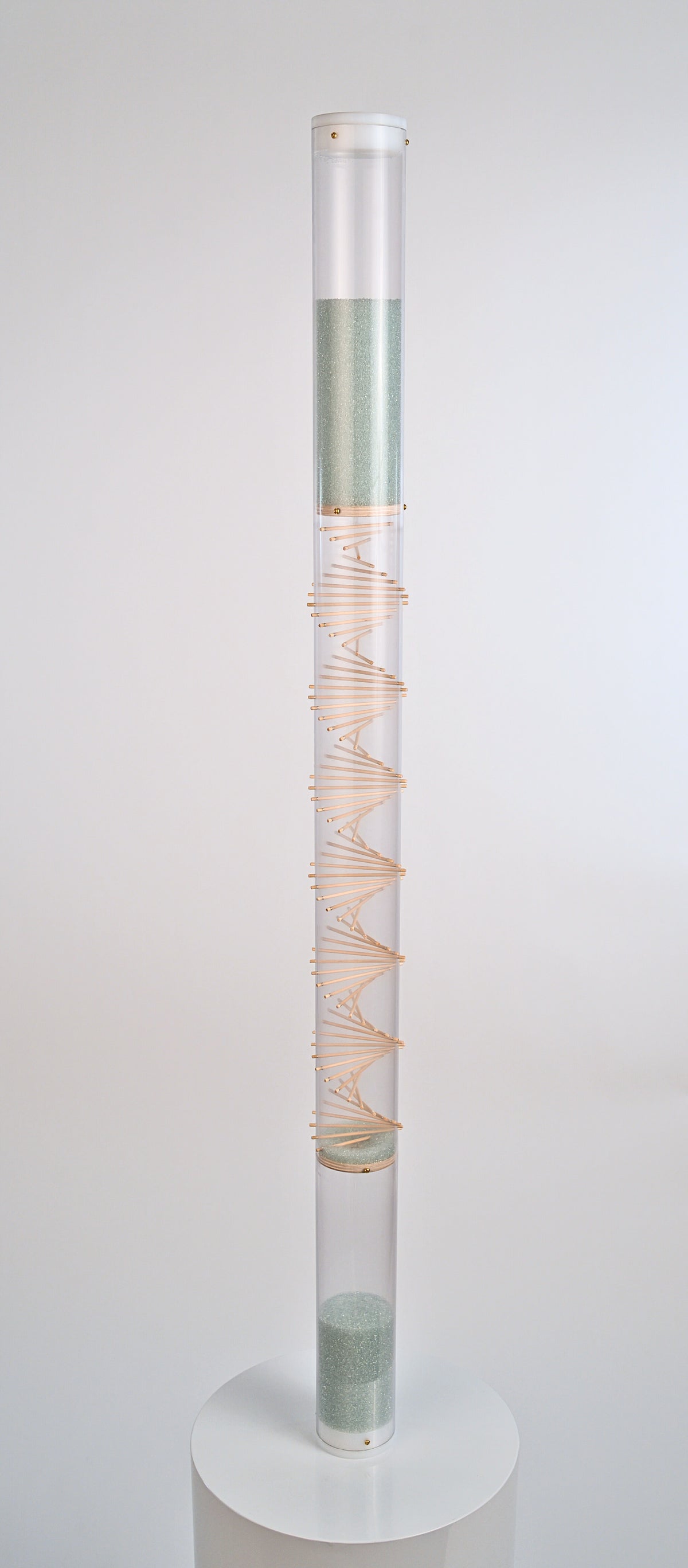 Pale blue beads shimmer in a 4' tall clear tube with a visible wooden spiral. The beads are flowing from top to bottom and a sound is produced when they hit and bounce off of the visible spiral. The rain sound lasts for 10 minutes. This rainstick by Rainstick Dreams is recommended as a sound healing tool by wellness and sound practitioners.