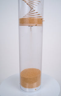Millions of tiny tan amaranth seeds flow into the bottom reservoir of a clear tube that’s enclosed by a custom fit white cap at the bottom. The 20 minute XL Amaranth Rainstick by Rainstick Dreams produces a gentle long duration rain sound that is calming and soothing. It’s enjoyable for meditation or as a sleep aid.