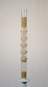 Two foot tall clear spiral sounds rainstick filled with tan amaranth seed. There is a visible wooden spiral going through the middle of the clear tube. The rainstick has white end caps on the top and bottom of the instrument. The rainstick instrument is on a white pedestal with a white background.