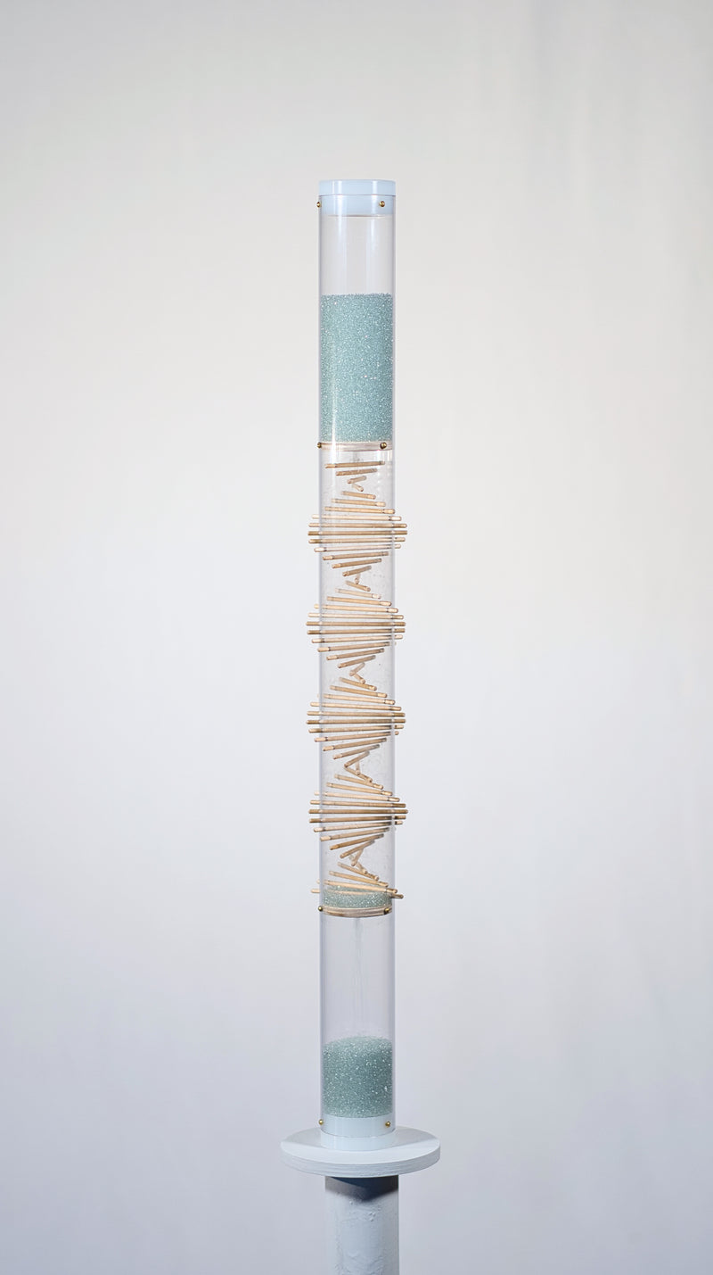 Pale blue beads shimmer in a clear tube with a visible wooden spiral. The beads are flowing from top to bottom and a sound is produced when they hit and bounce off of the visible spiral. This is a 90 second spiral rainstick made by Rainstick Dreams.