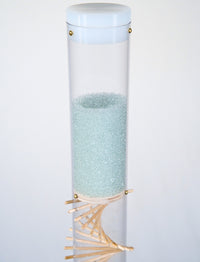 Pale blue beads shimmer in a clear tube with a visible wooden spiral. The beads are flowing from top to bottom and a sound is produced when they hit and bounce off of the visible spiral. The rain sound lasts for 90 seconds. This is a spiral rainstick made by Rainstick Dreams.
